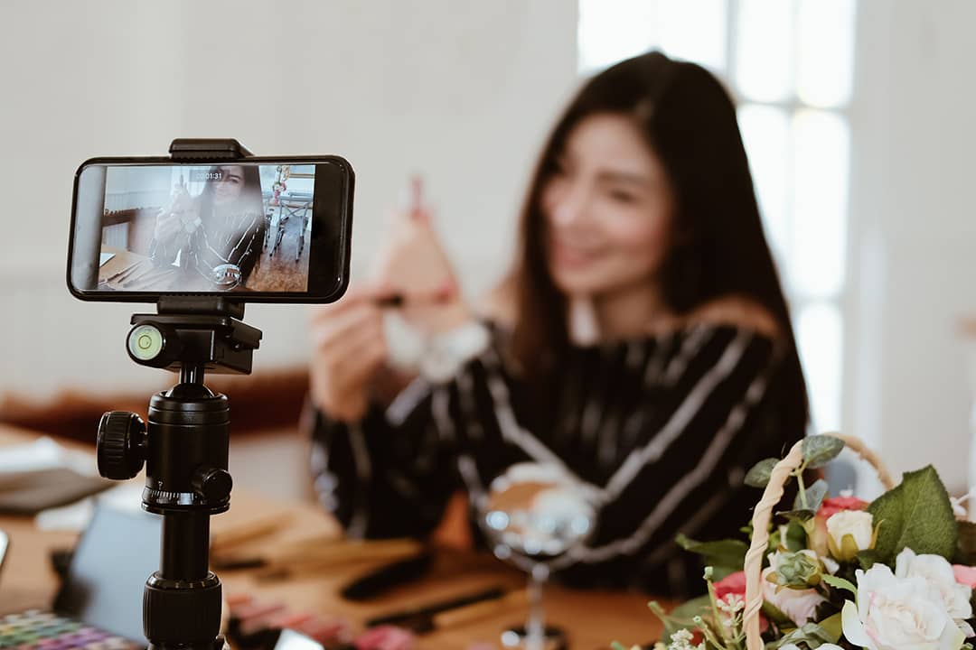 A beauty vlogger broadcasting a makeup tutorial live from her social media account.